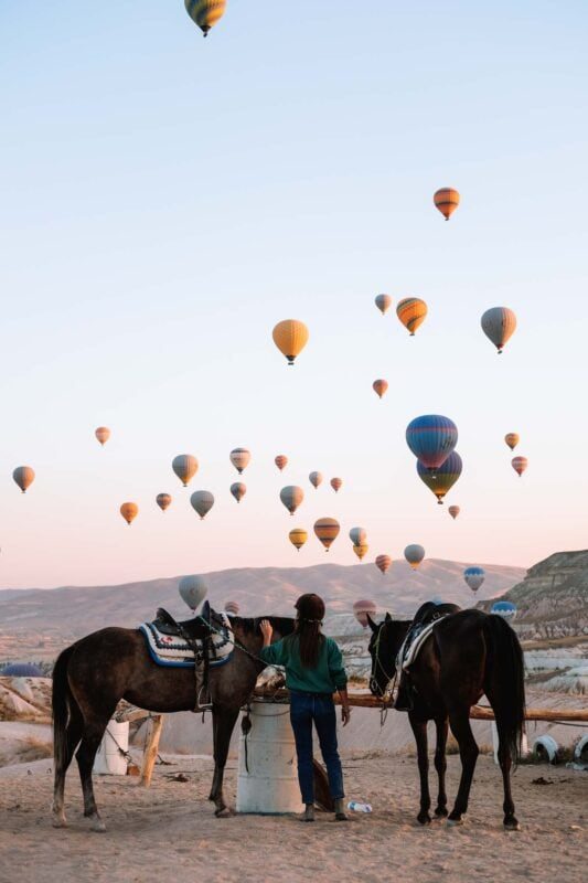 Tijdens het paardrijden in Cappadocië vliegen er tientallen luchtballonen rond
